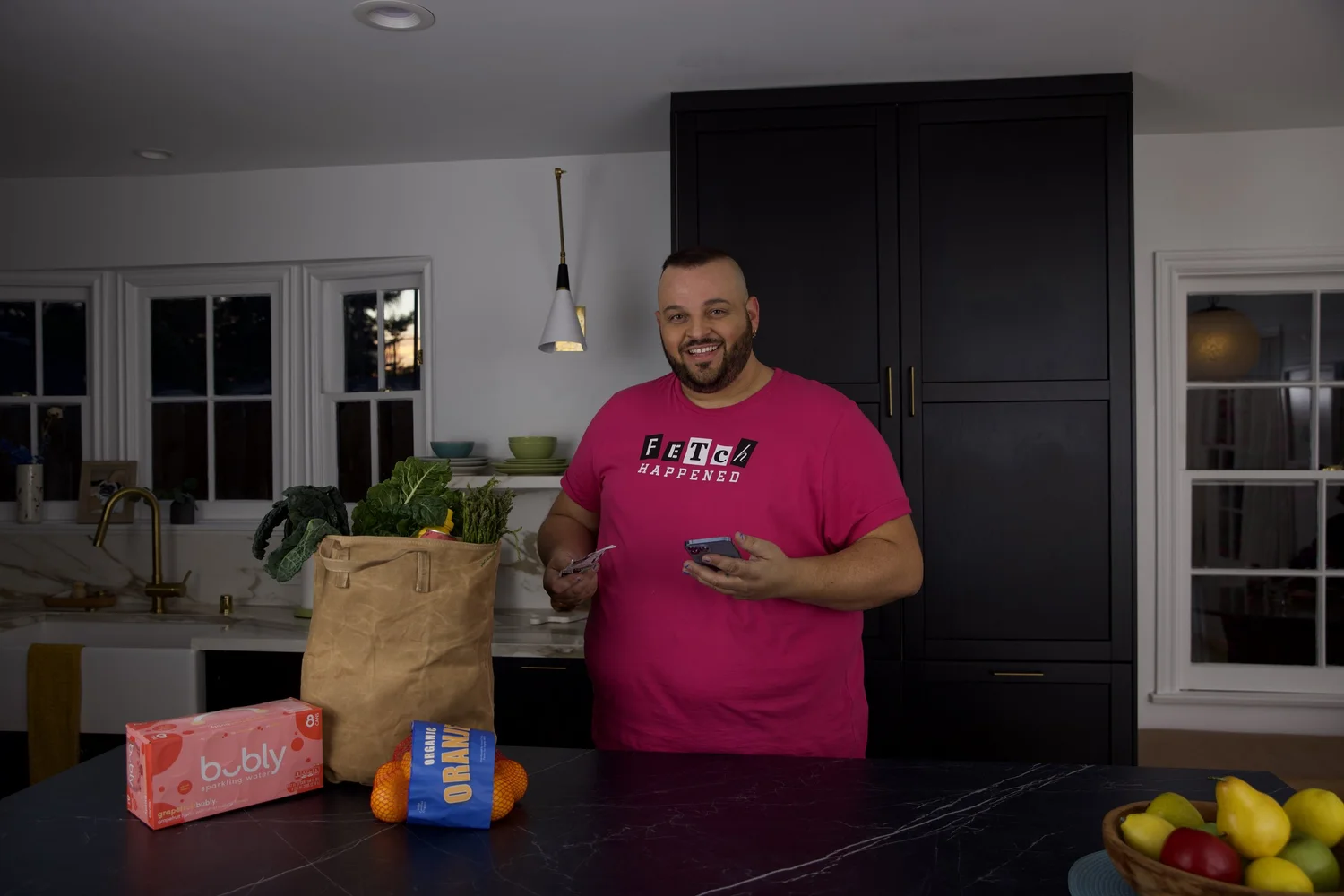 Daniel Franzese in a Fetch Happened tee, unpacking groceries in a kitchen