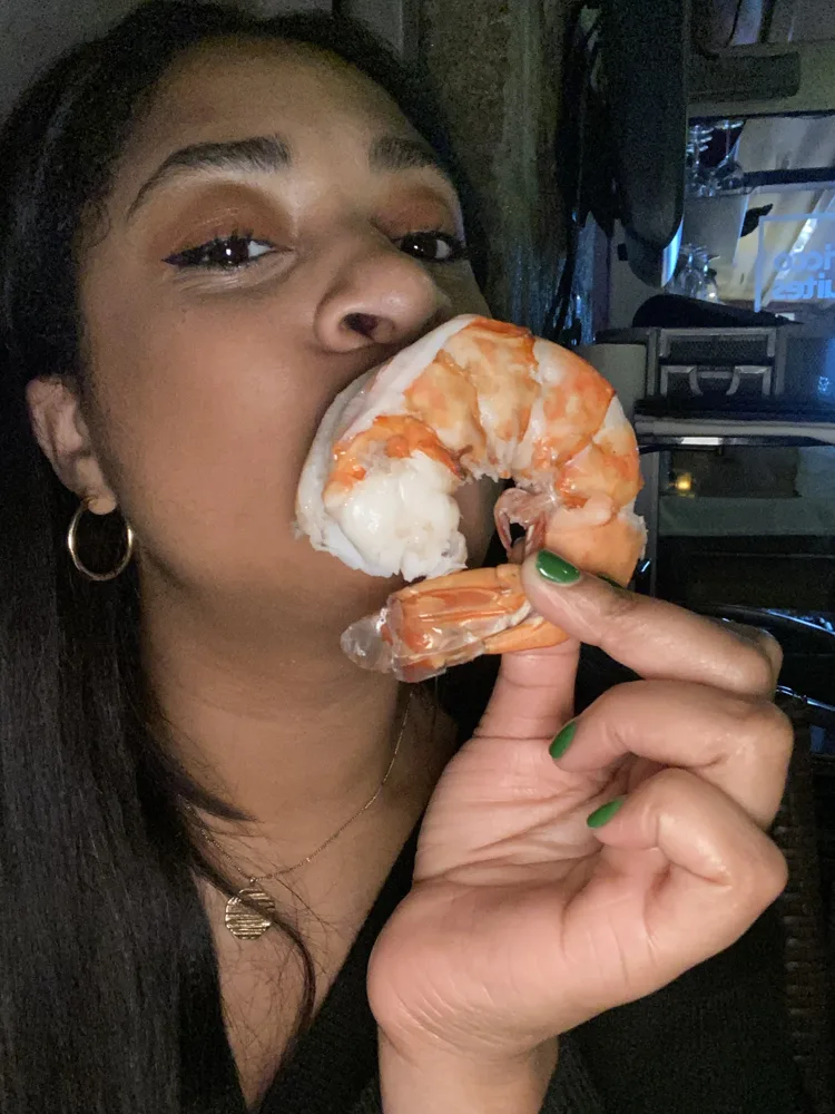 Whitney taking a bite of a giant shrimp